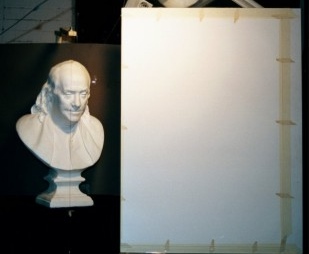 A photograph of a plaster cast placed next to a drawing board.