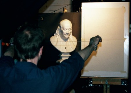 A photograph of an artist demonstrating using the sight size method.